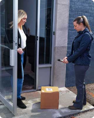 A women delivering a parcel and scanning it with a mobile device